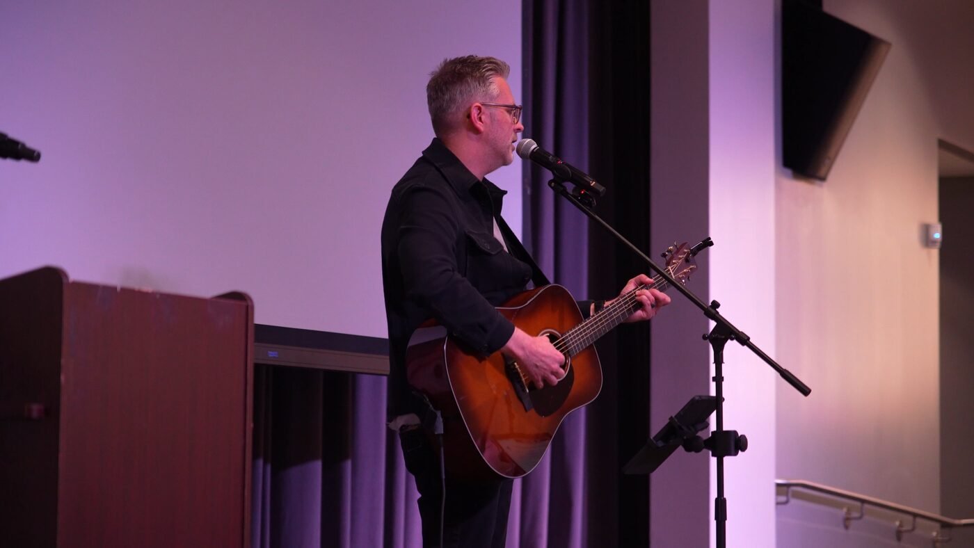 Guitarist performing on stage in a venue — professional live event video capture