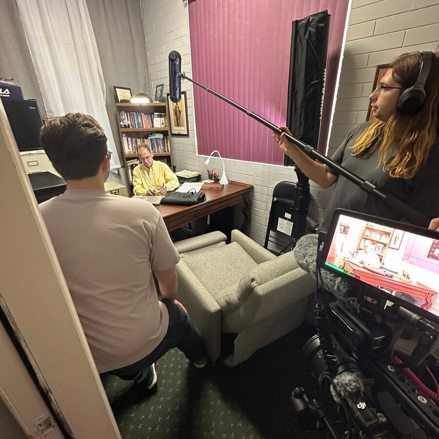 Interview setup in an office with boom microphone, lighting and camera monitor