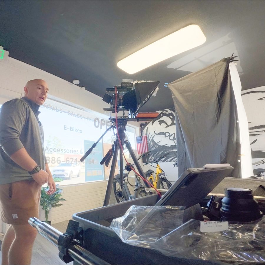 Nathan setting up a camera and teleprompter inside a local business